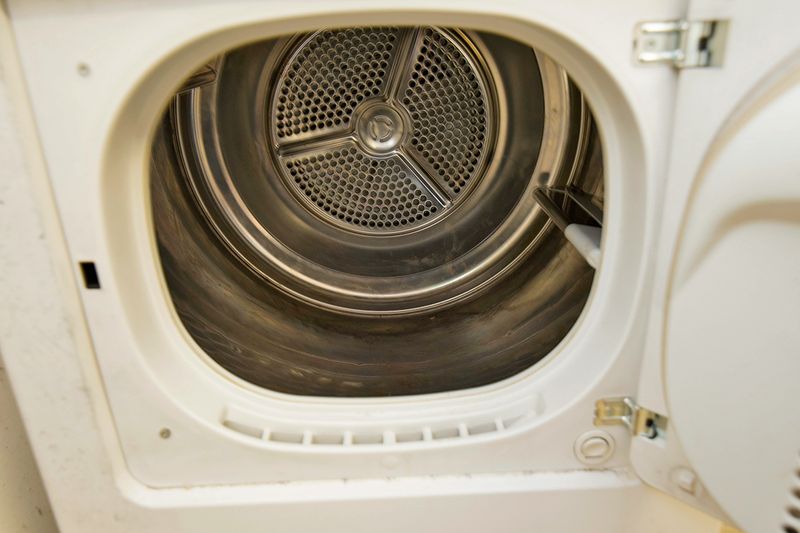 An open, empty dryer. It's a white, older, front-loading model.