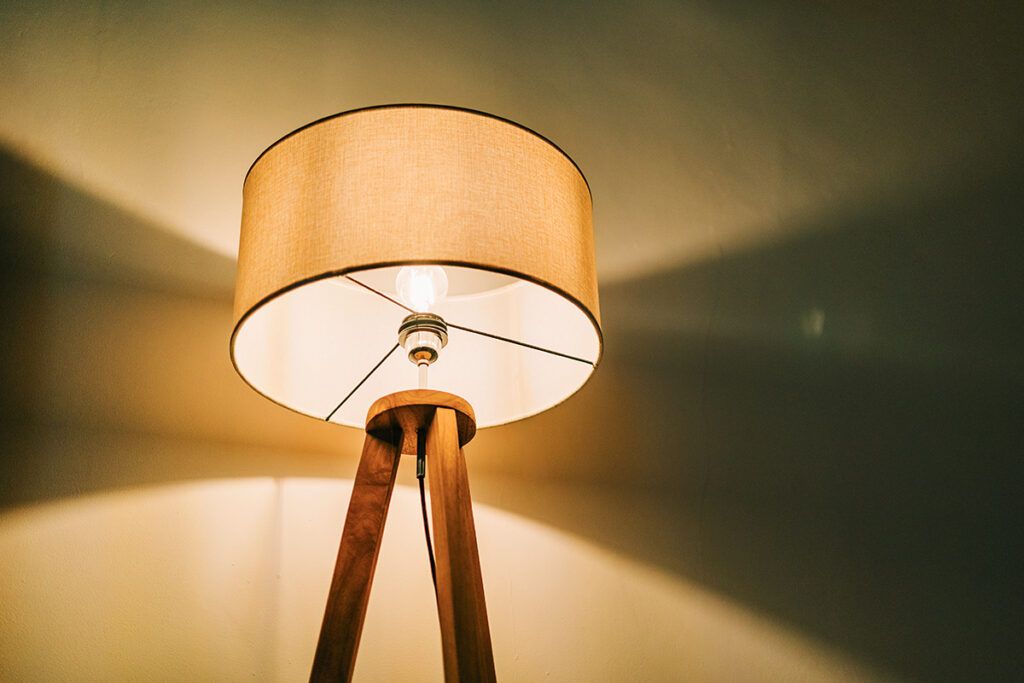 An illuminated floor lamp in a dark room.