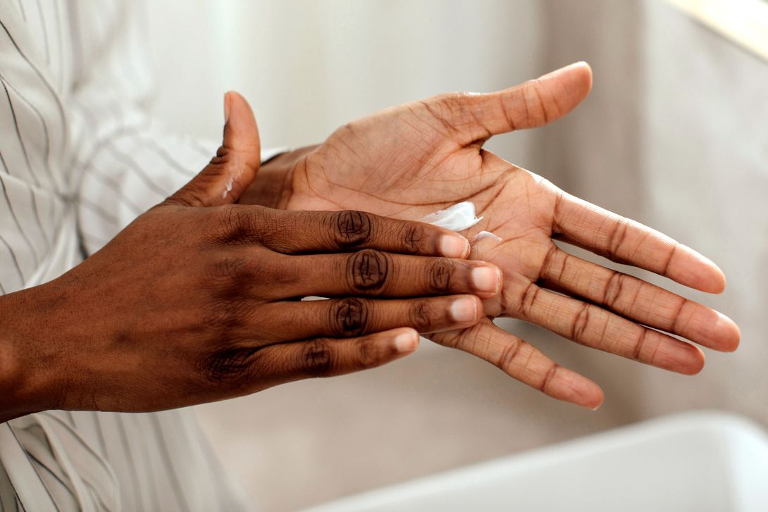 An image of a person rubbing lotion on their hands
