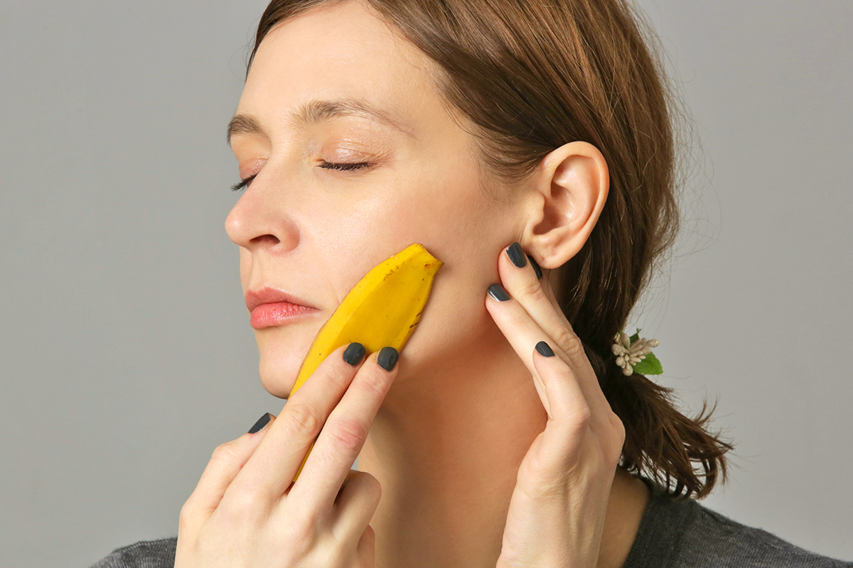 Woman running banana peel on face
