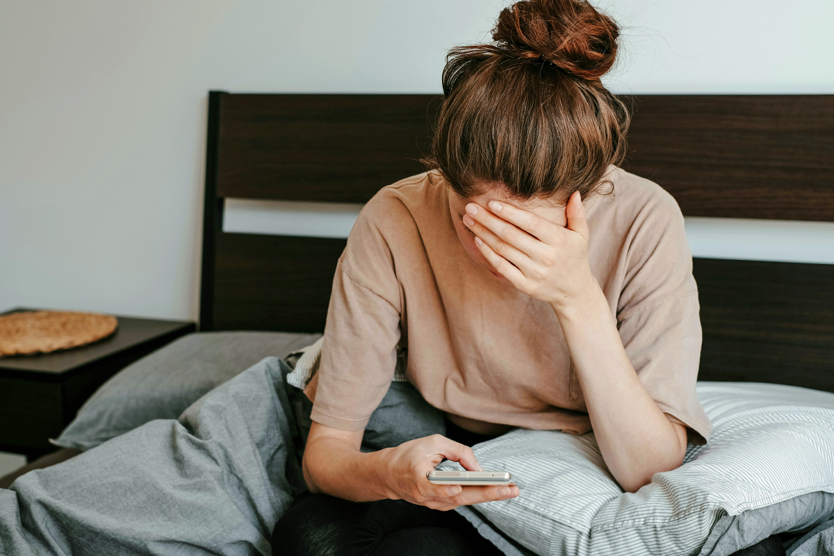 Woman looking at phone in bed