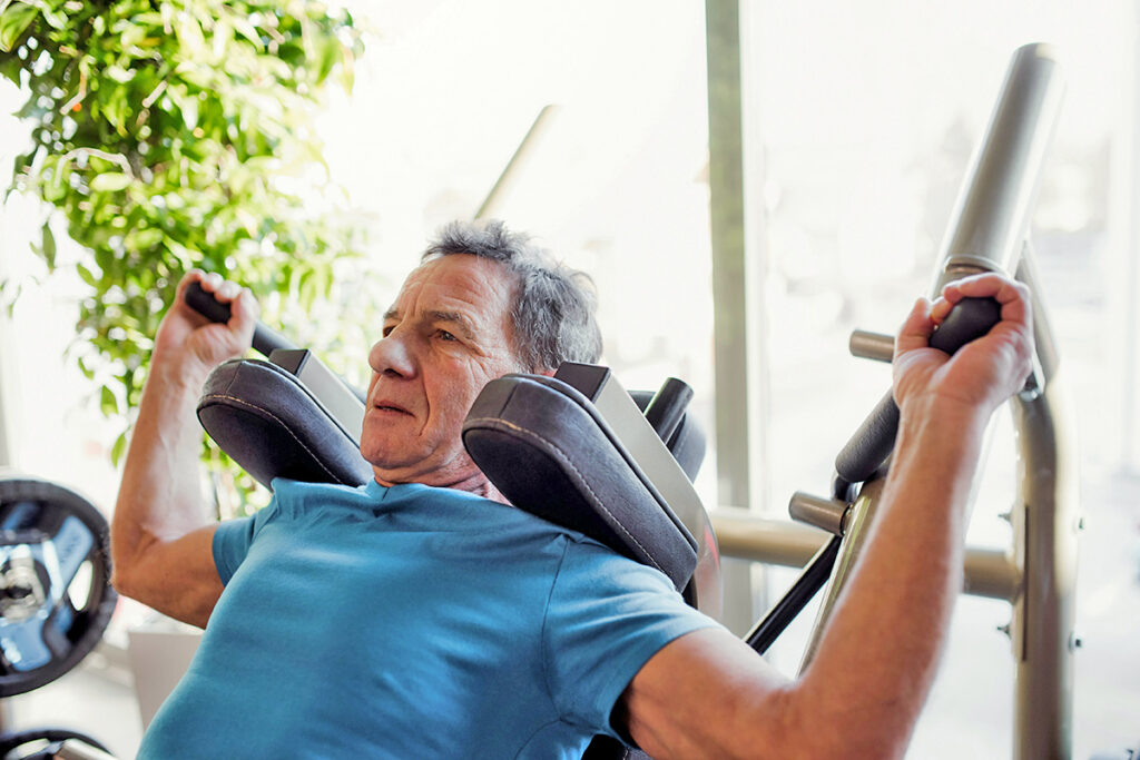Man working out on weight lifting machine at the gym