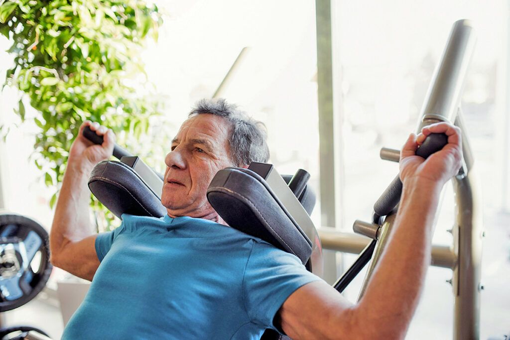 Man working out on weight lifting machine at the gym