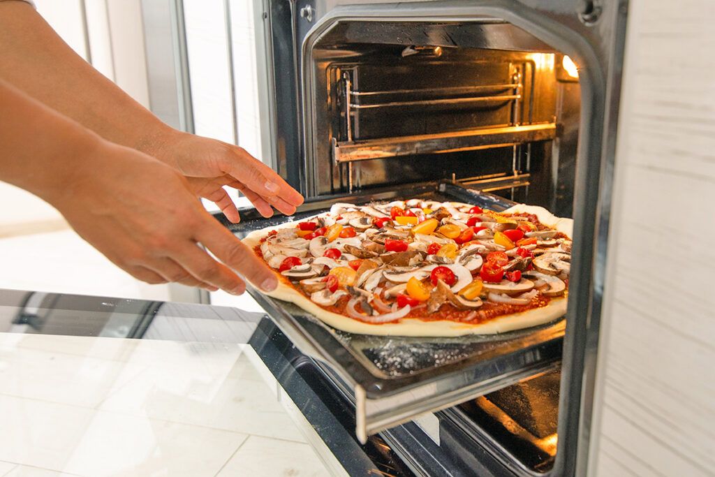 Pizza going into oven