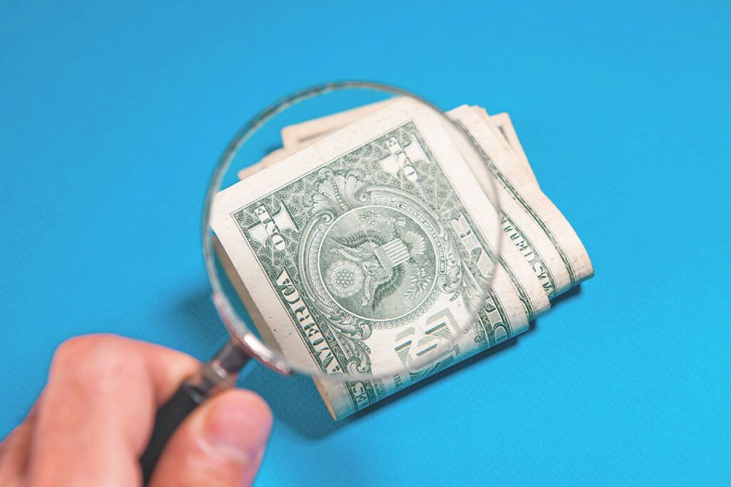 $1 bill under a magnifying glass