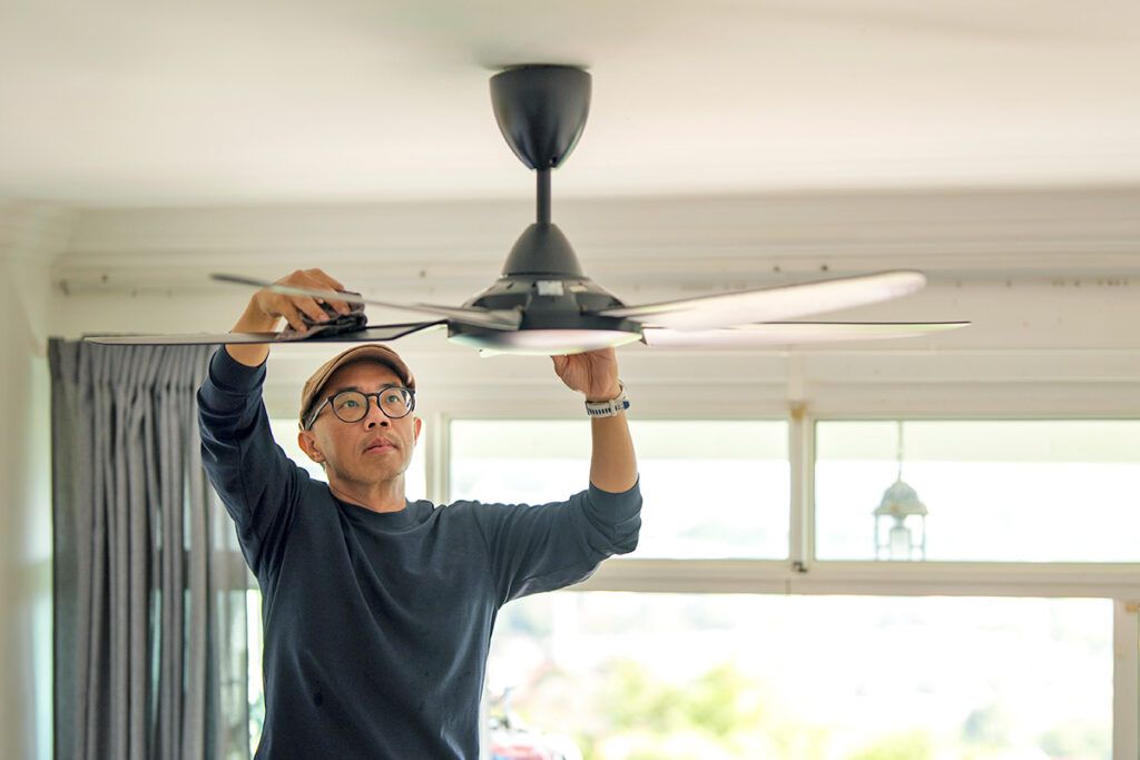 Man dusting ceiling fan