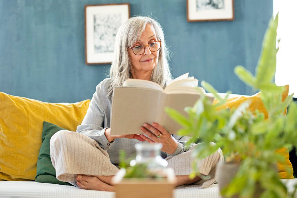 Woman reading book on couch