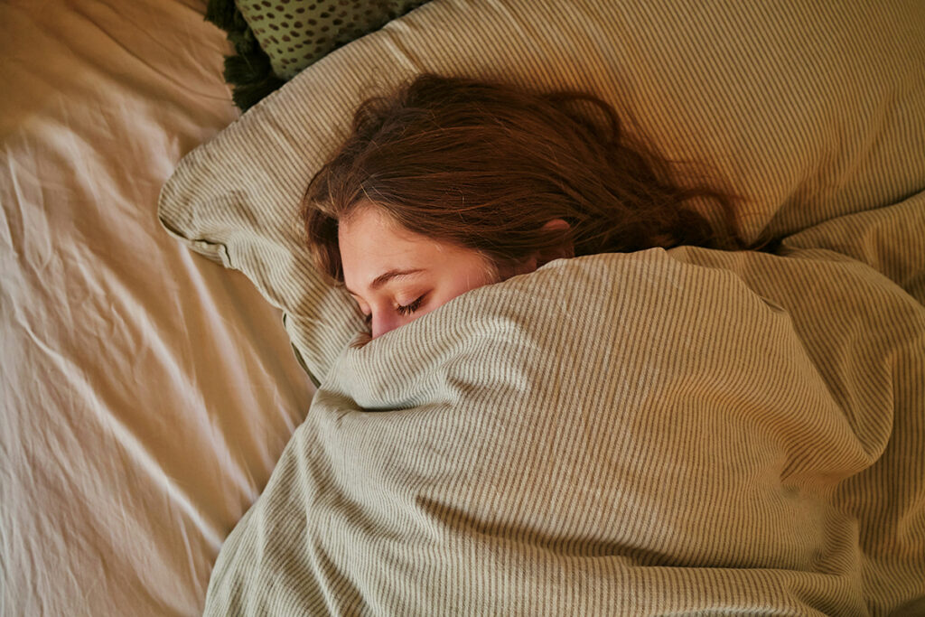 Woman asleep with blankets up to nose
