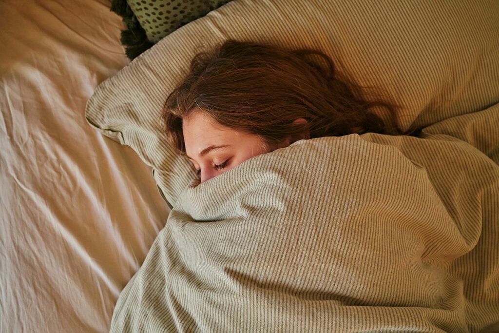 Woman asleep with blankets up to nose