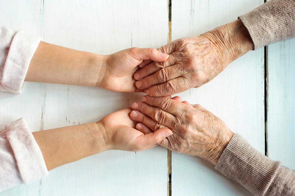 Senior hands holding child hands