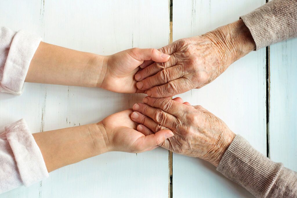 Senior hands holding child hands