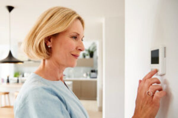 Woman setting thermostat