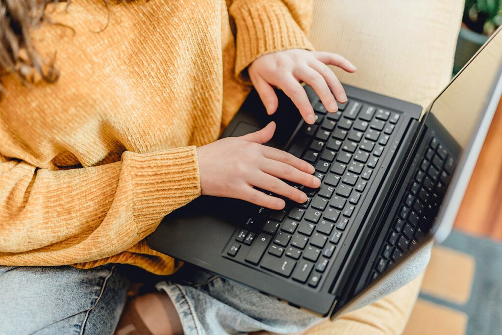 Hands typing on keyboard laptop