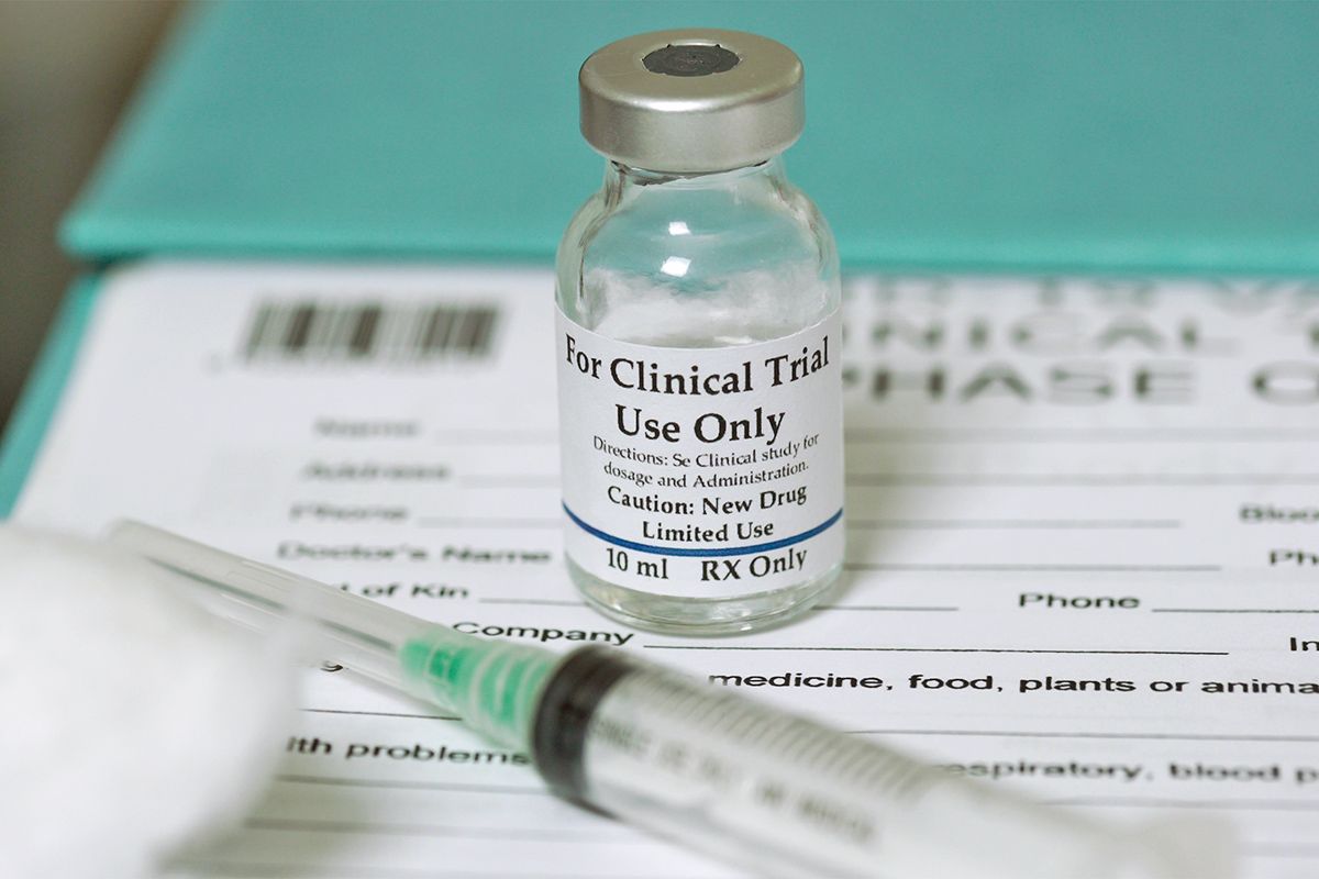 Syringe and bottle of liquid on paper