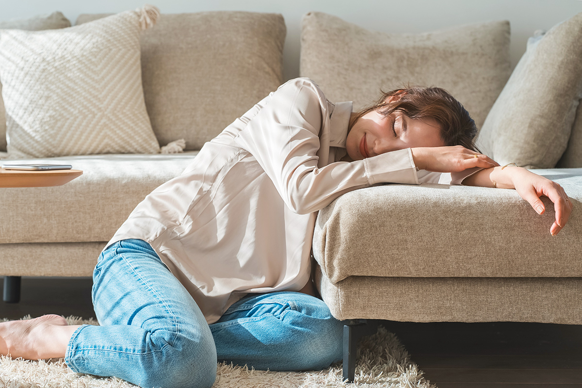 Woman with head down on couch