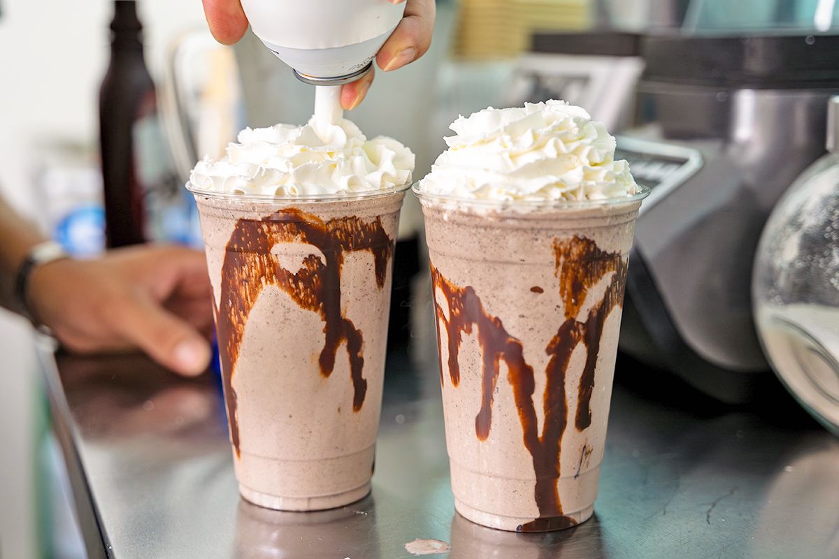 Putting whipped cream on a milkshake