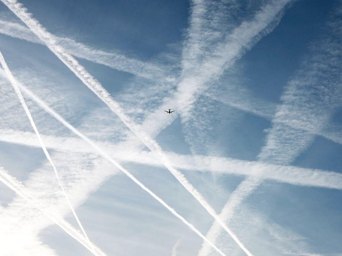 Plane flying overhead through contrails