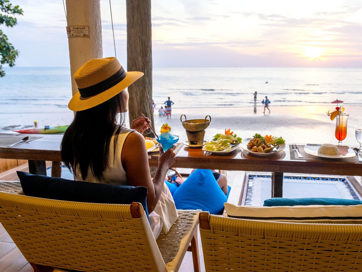 Woman enjoying meal overlooking beach