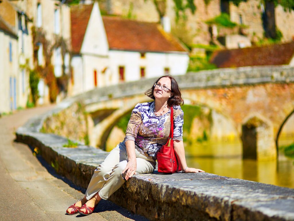 Woman sitting on wall in Burgundy, France
