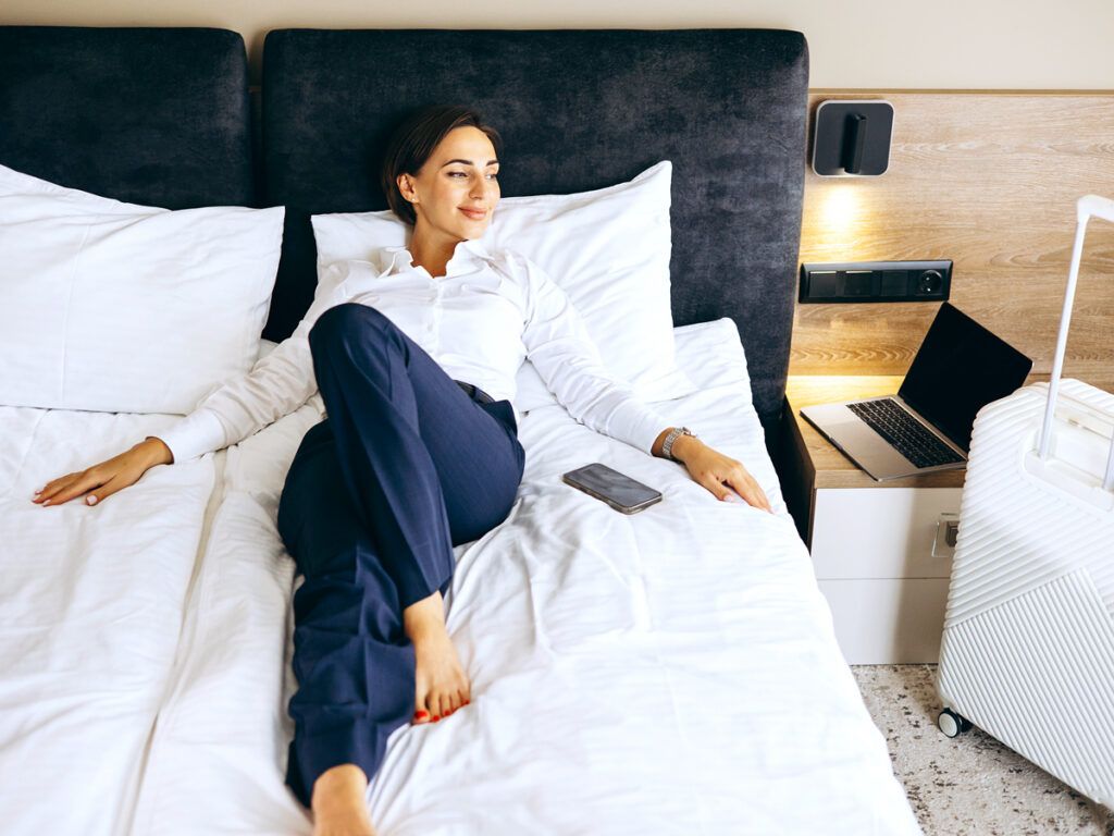 Woman relaxing on hotel bed
