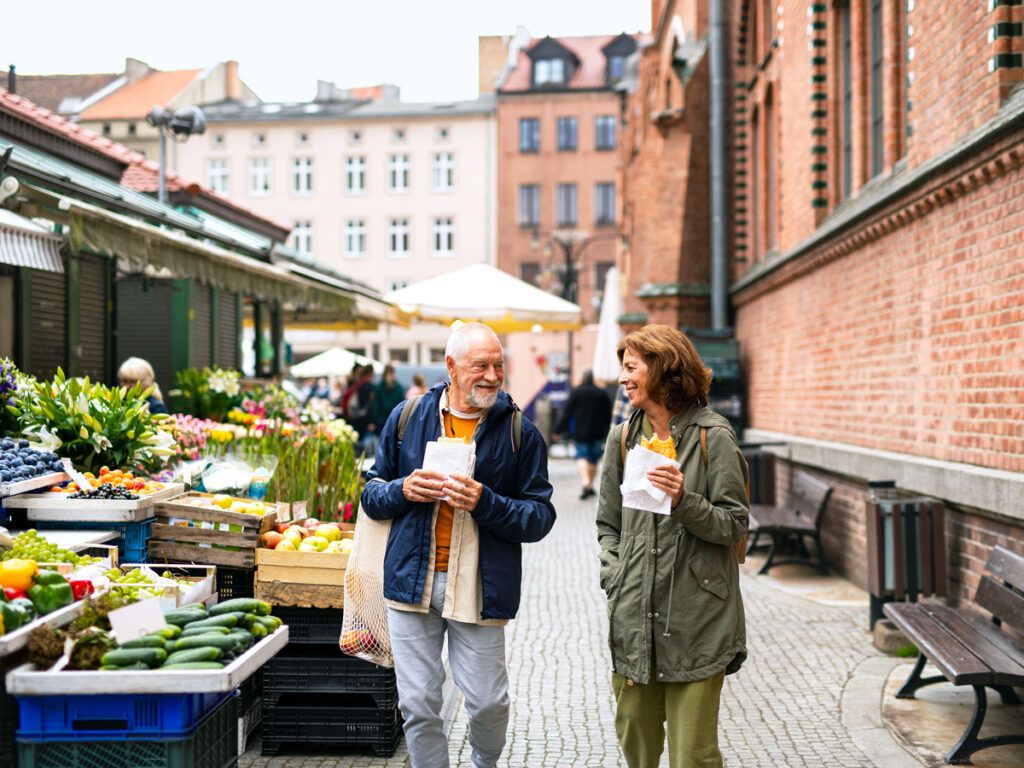 Senior couple walking through outdoor food market