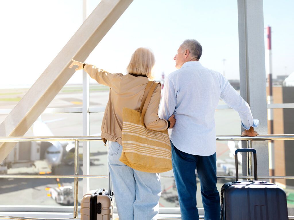 Couple looking out window in airport terminal