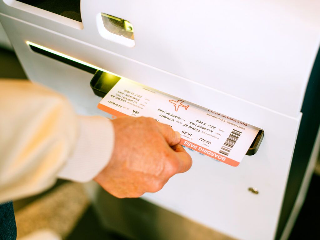 Passenger printing boarding pass from airport kiosk