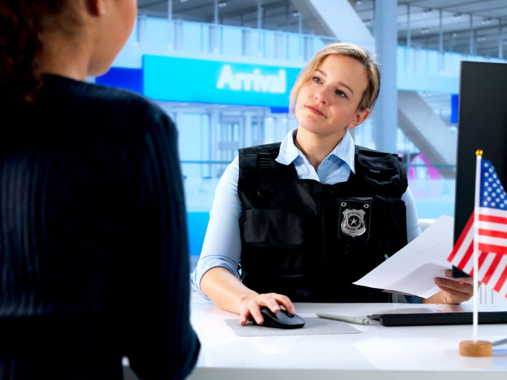 Customs officer interviewing arriving passenger
