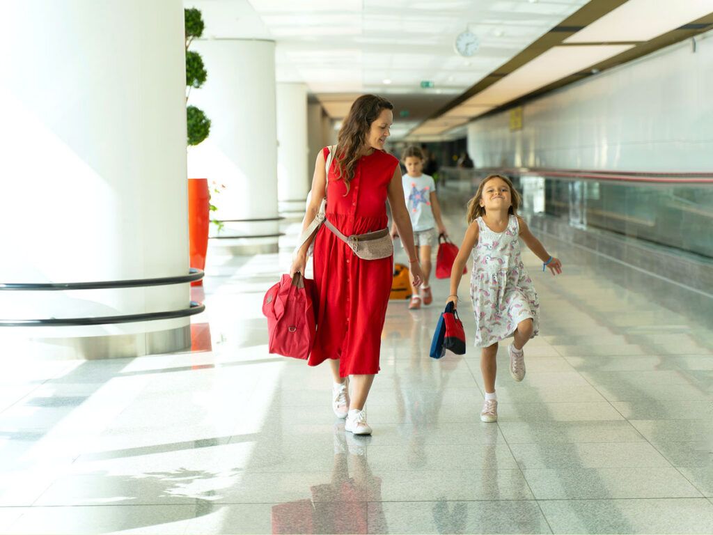 Mother and child walking through airport terminal