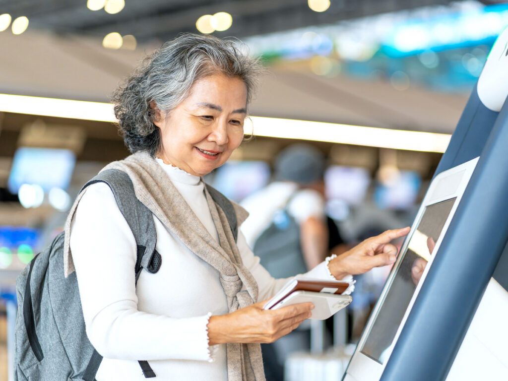 Traveler using electronic kiosk to check in at airport