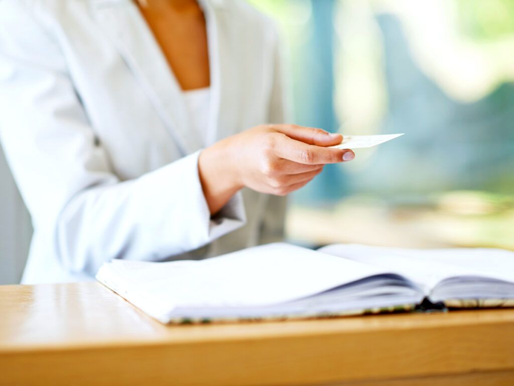 Hotel clerk handing guest a business card