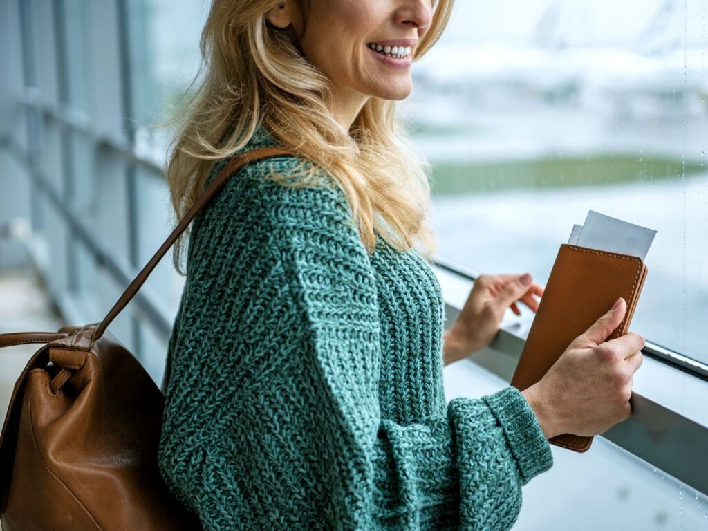 Traveler wearing backpack looking out terminal window