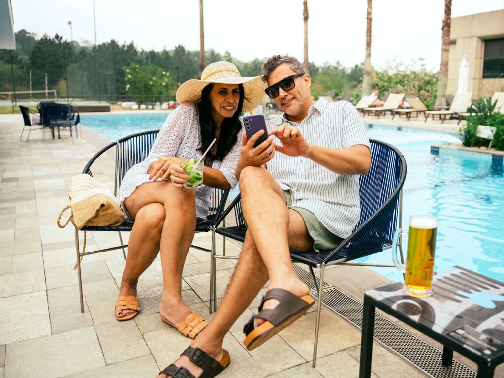 Two guests sitting in chairs by resort pool