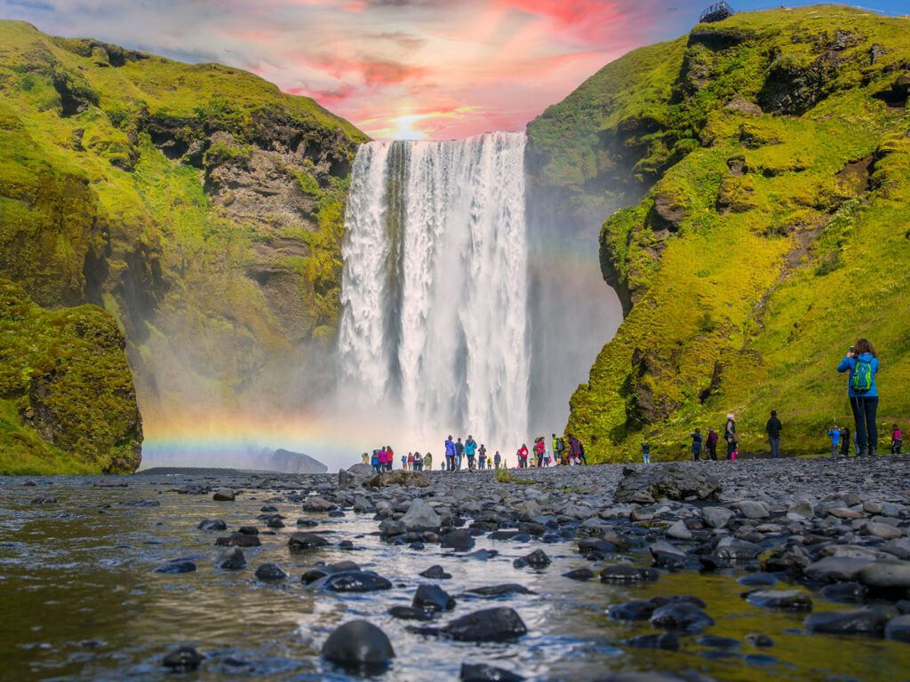 Tourists gazing at Iceland's Skogarfoss waterfall