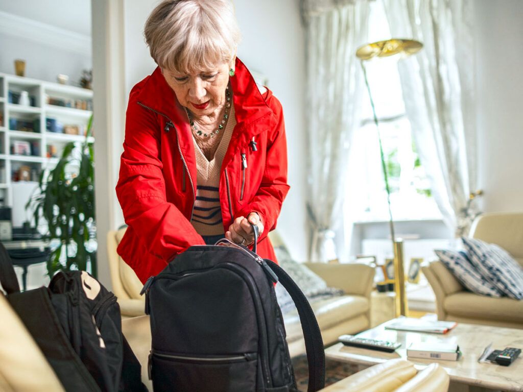 Traveler packing items in backpack