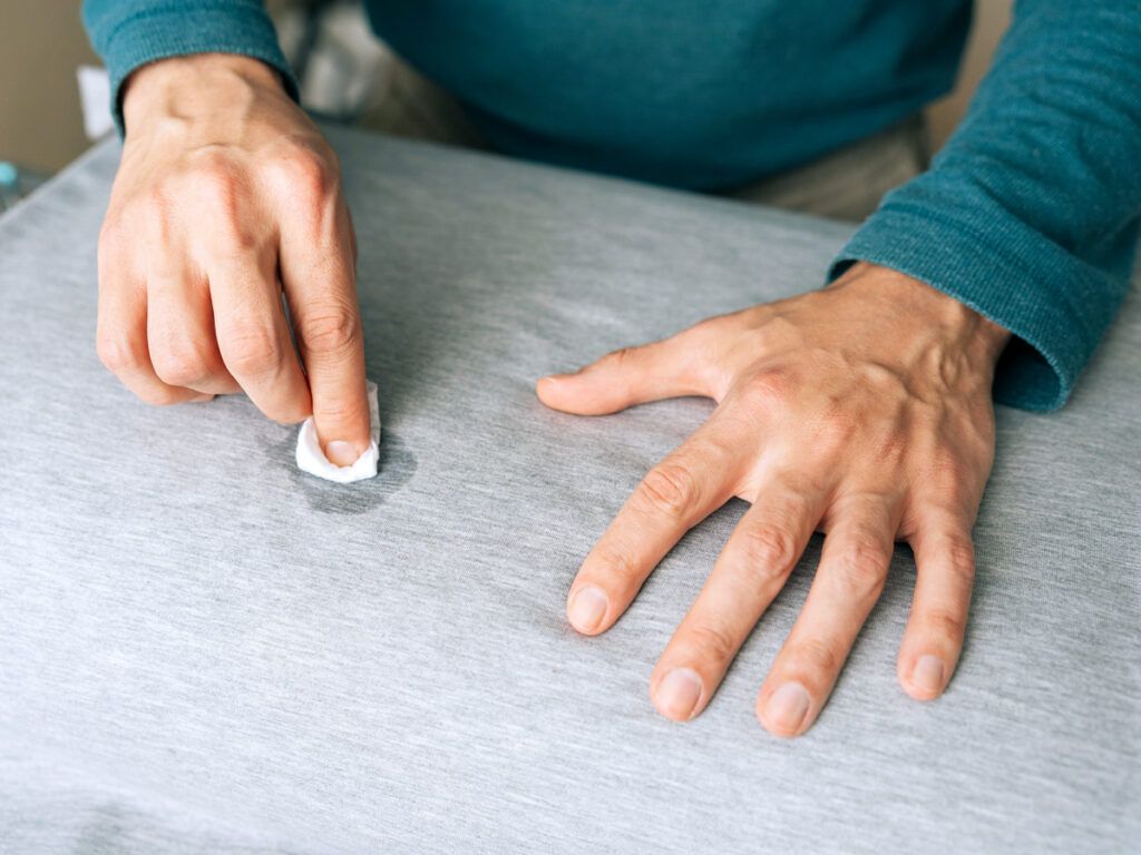 Person removing stain from shirt