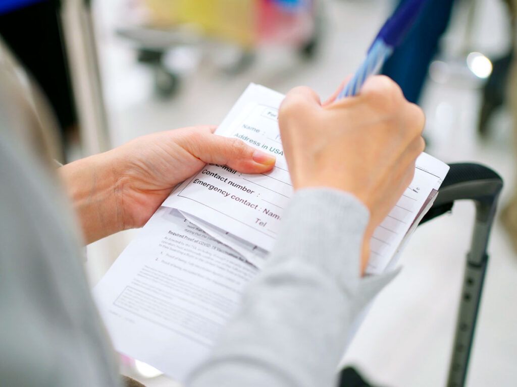 Traveler filling out customs declaration form