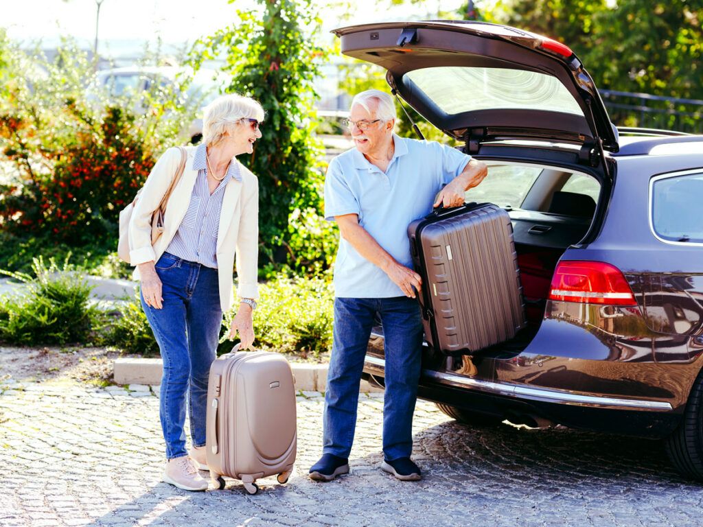Couple unloading luggage from car