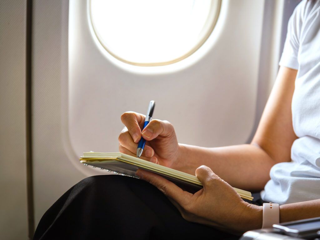 Airline passenger writing in notebook