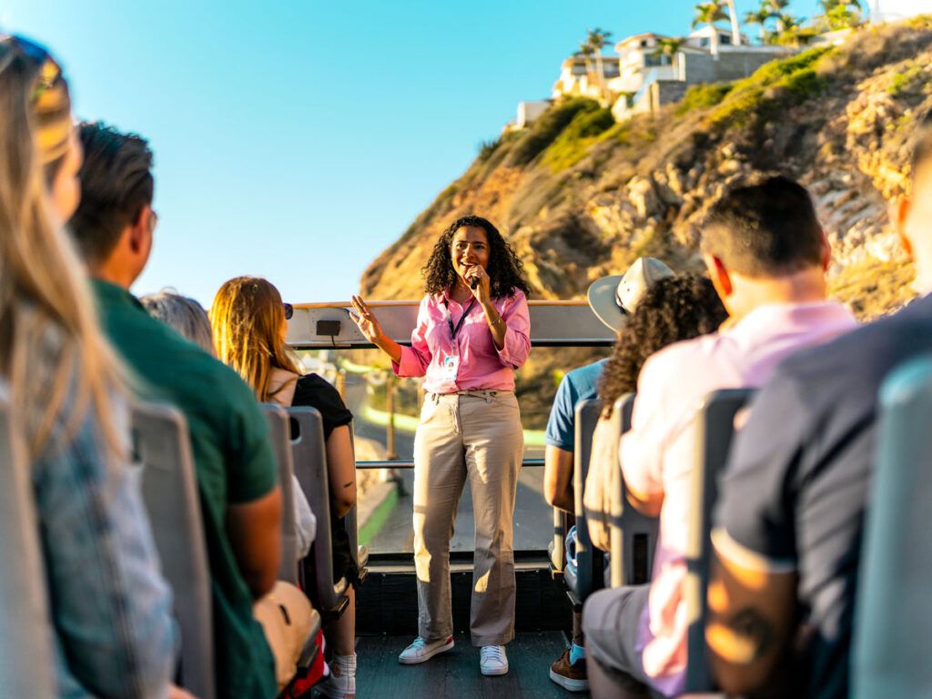 Tour guide on bus speaking into microphone