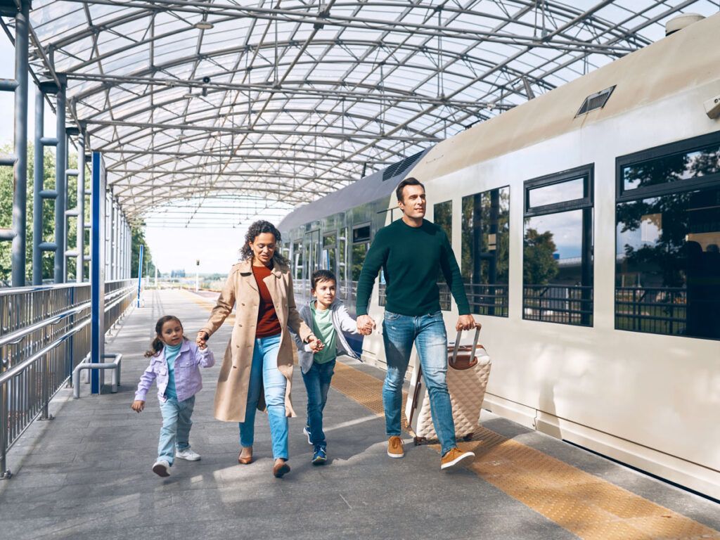 Family walking through train station with luggage