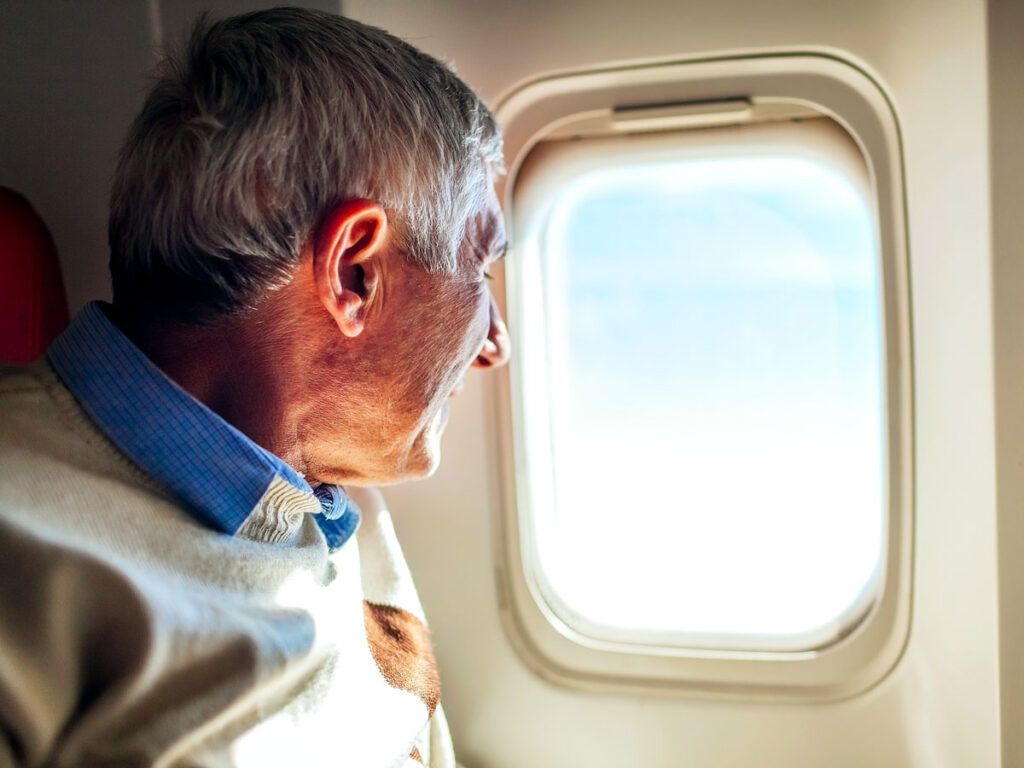 Traveler looking out airplane window
