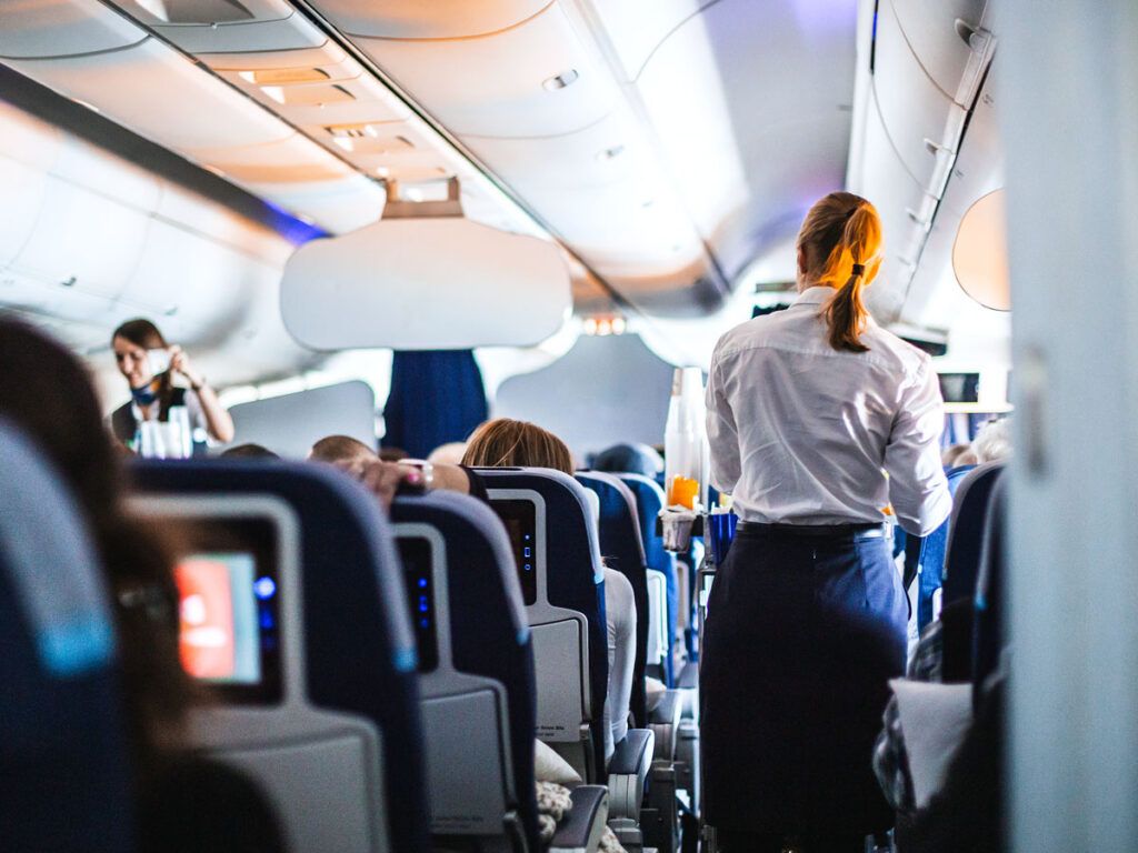 Flight attendants with beverage carts in aisle