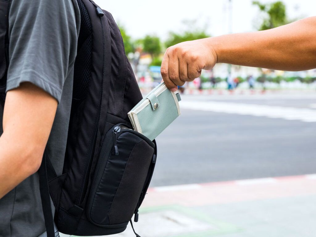 Pickpocket stealing wallet from tourist's backpack
