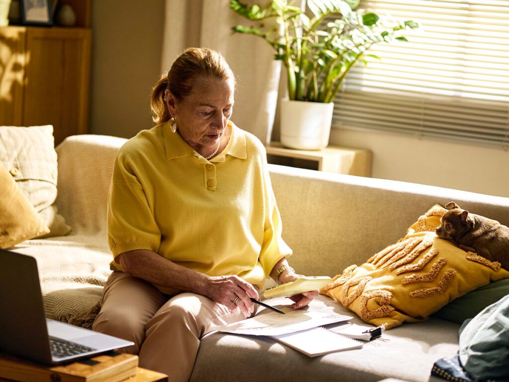 Woman doing calculations on sofa