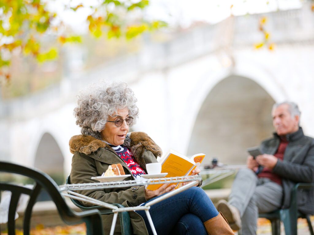 Woman reading a book at a park cafe 