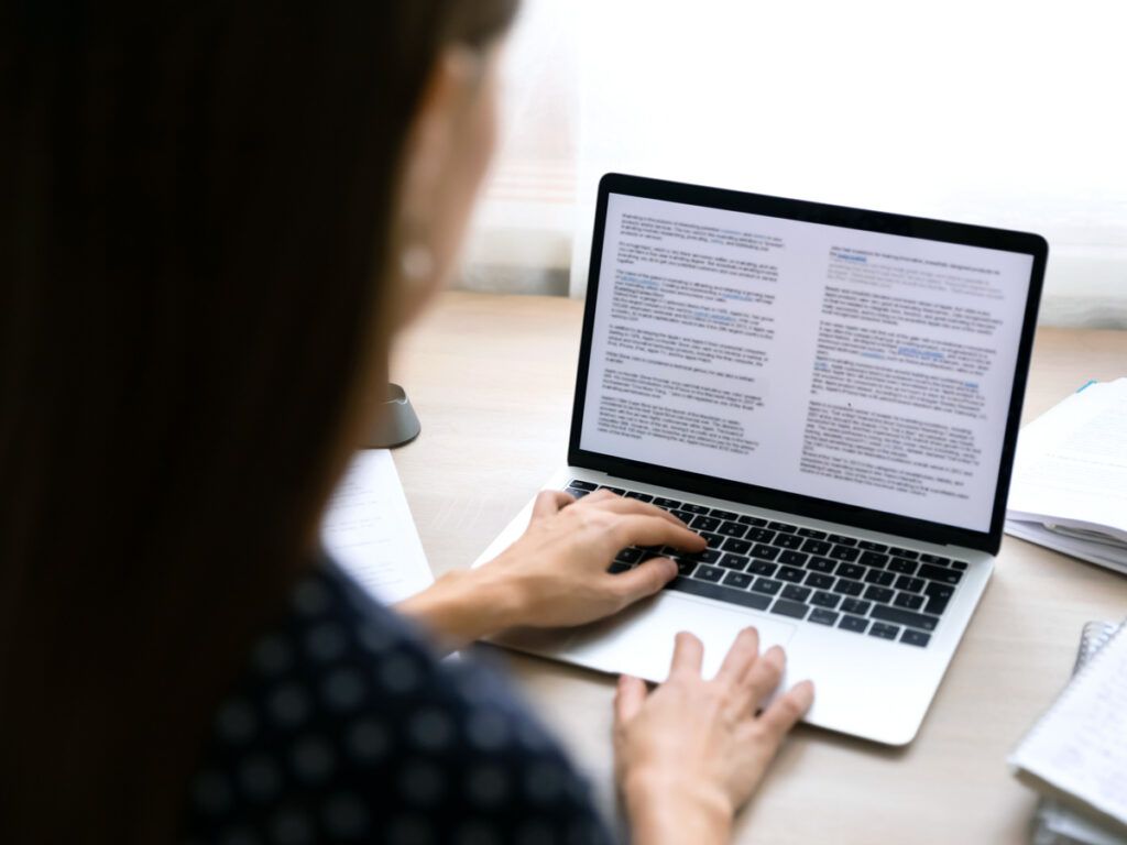 Businesswoman typing a document on her laptop