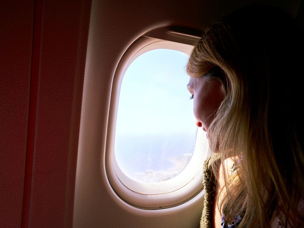 Woman looking out a plane window