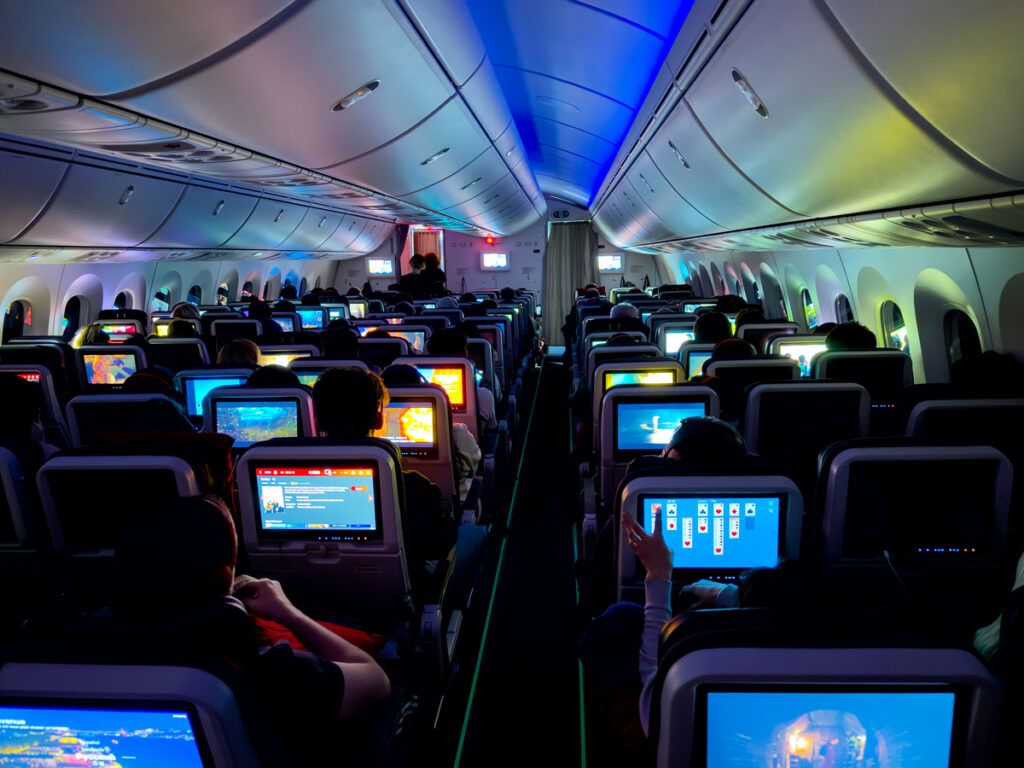 Passengers on a plane watch in-flight movies