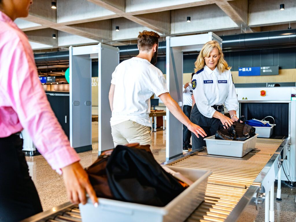 Man getting luggage screened at airport security